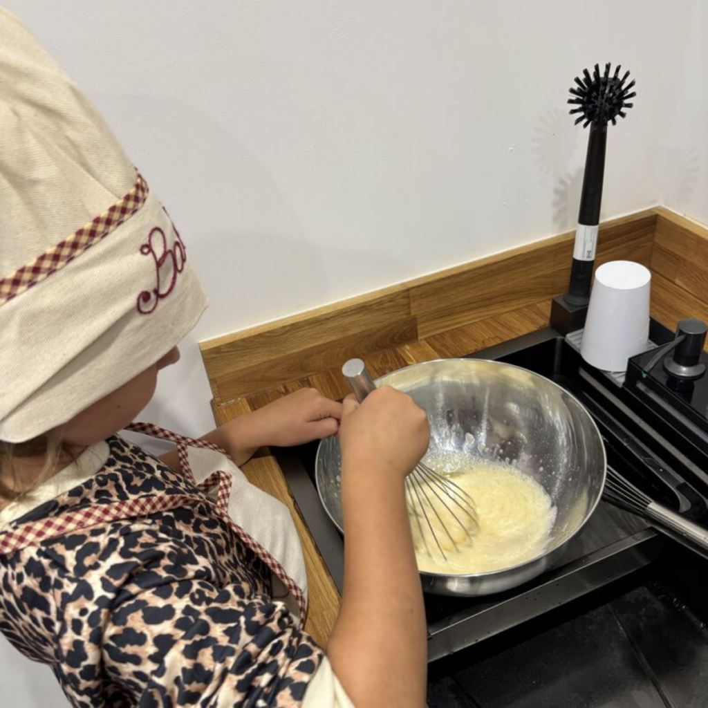 A young baker whisking the sponge mixture in the test bakery