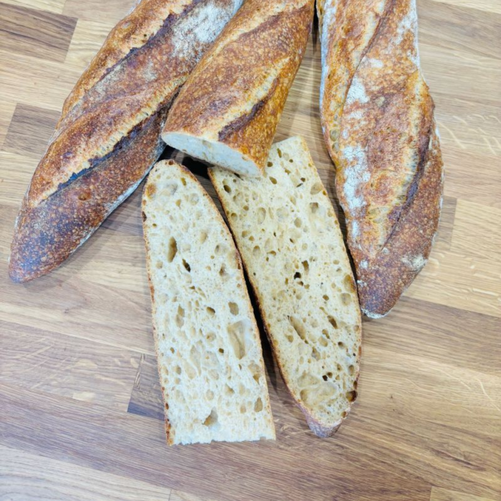 Sourdough baguettes showing crisp, well-scored crusts from sweet malt