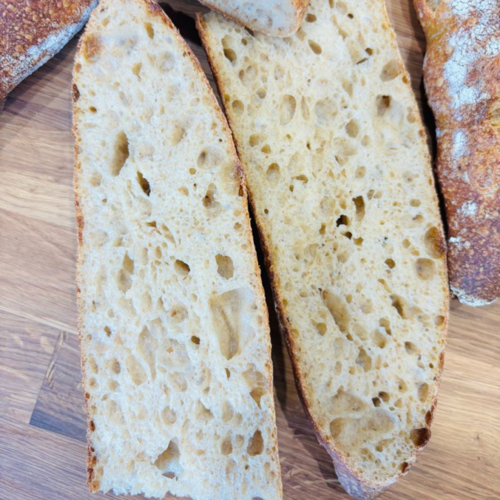 Open, irregular crumb of a cold-fermented sourdough baguette