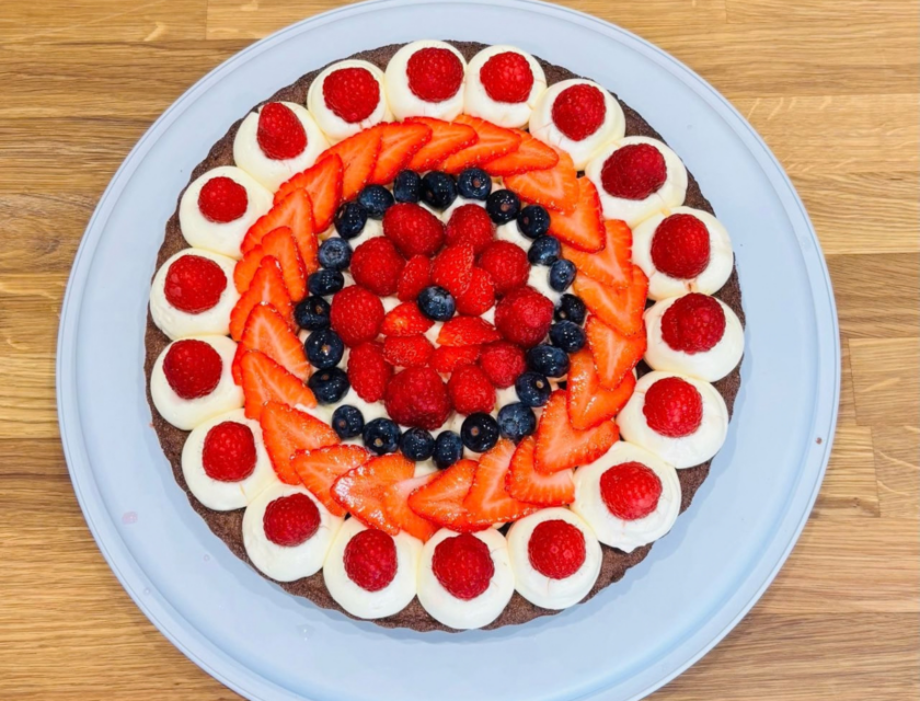 Fresh fruit flan topped with glazed strawberries, raspberries and blueberries