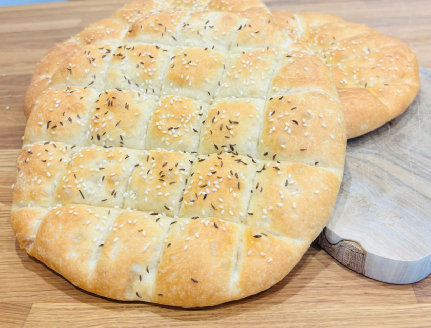 Sourdough kebab bread with a lattice-scored top and sesame seeds