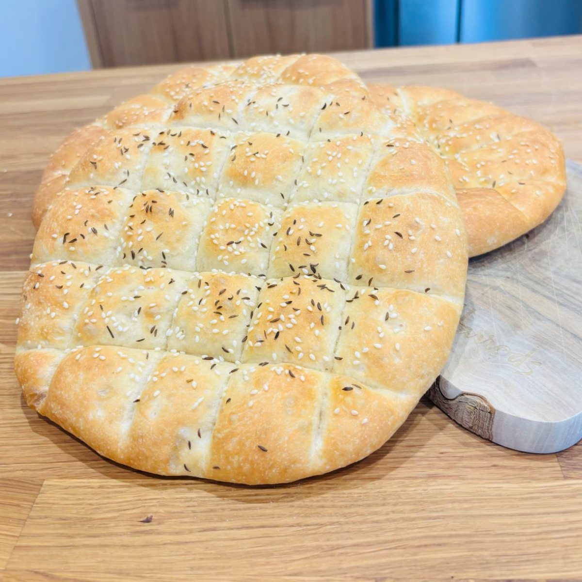 Sourdough kebab bread with a lattice-scored top and sesame seeds